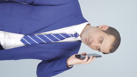 Vertical-video-of-Businessman-getting-interrupted-and-angry-while-talking-on-the-phone.